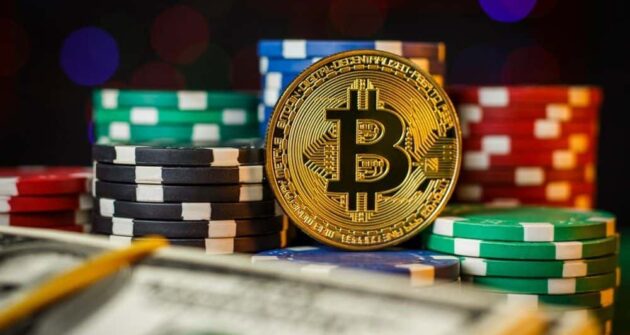 bitcoin laying next to poker chips on a table